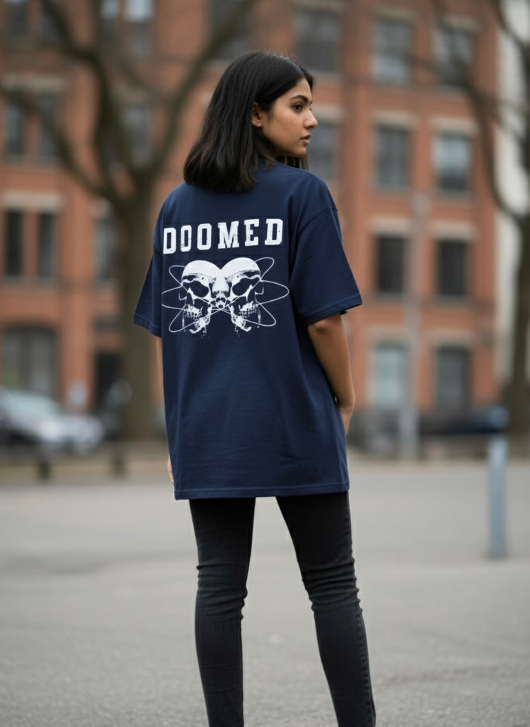Person wearing a Navy Blue t-shirt with 'DOOMED' text and skull design outdoors.