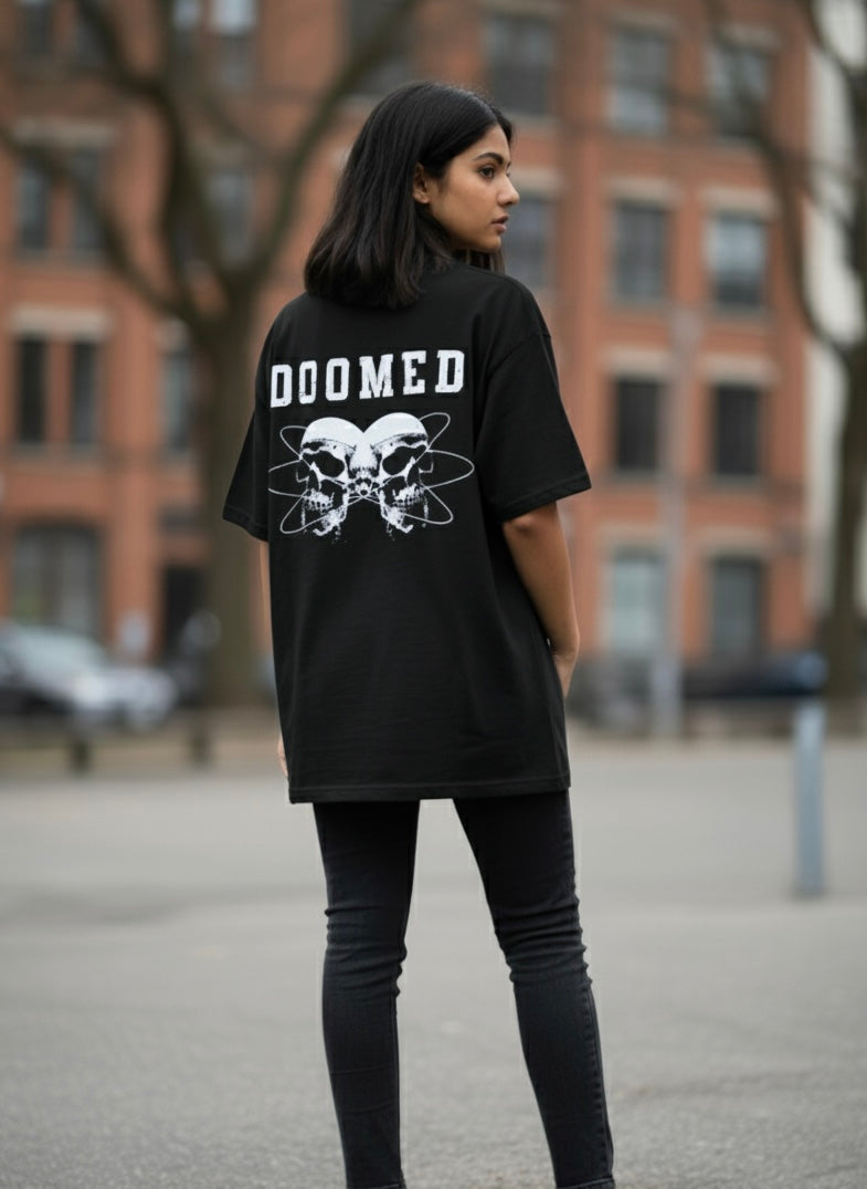 Person wearing a Black t-shirt with 'DOOMED' text and skull design outdoors.